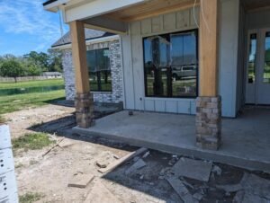 Front porch of a house under construction with stone and wood accents.