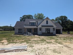 A white farmhouse-style house with a black roof and black window frames.