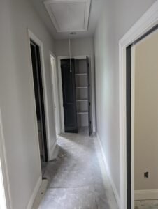 Newly installed black closet doors and interior doors in a room under construction.